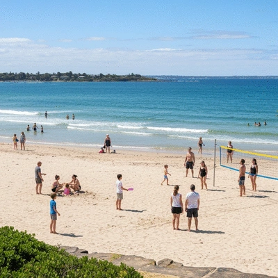People of all ages enjoying various activities on Mordialloc Beach, with clear skies and calm water, embodying community spirit